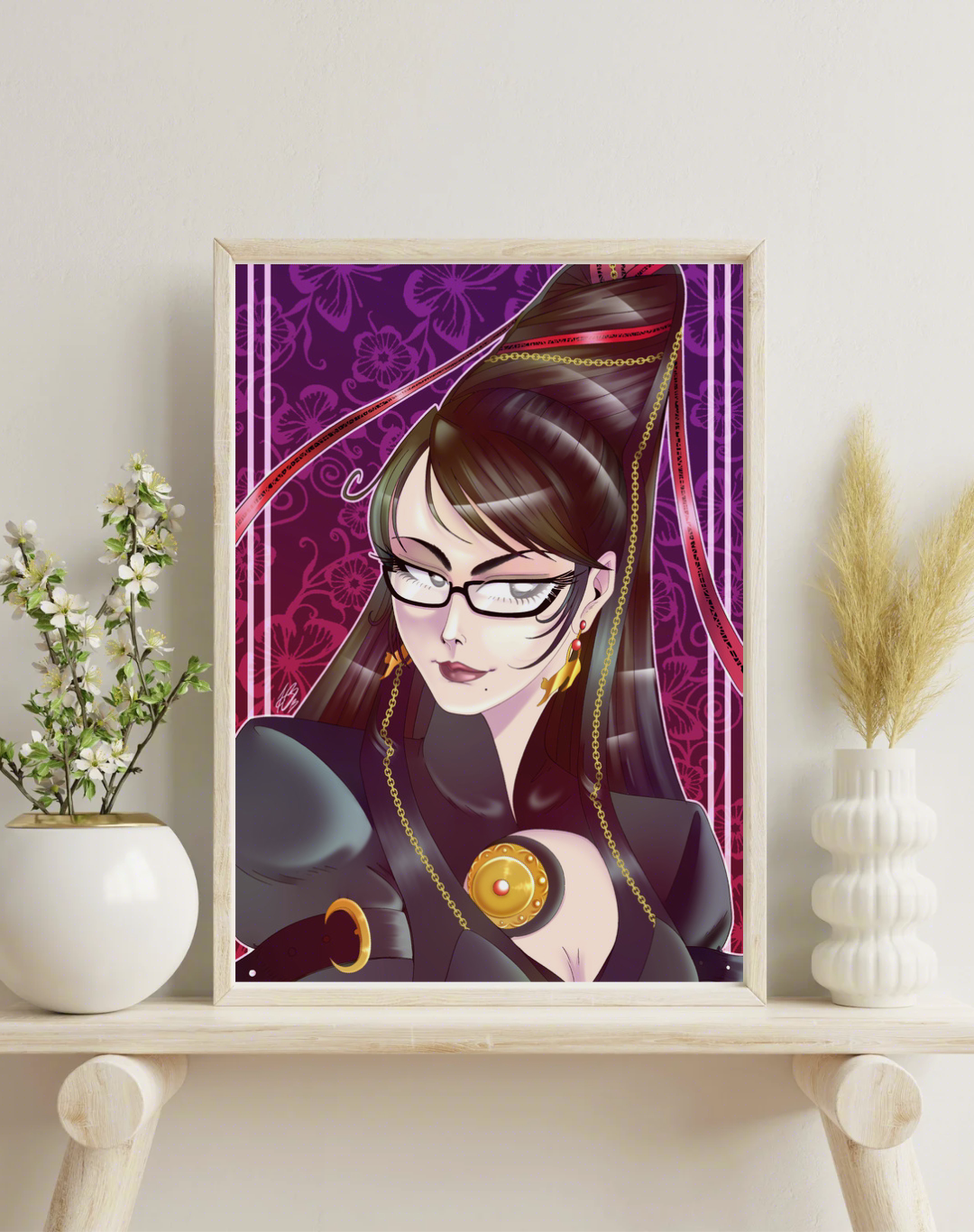 The aforementioned illustration framed in a mock up wooden frame, on a white wooden shelf with potted plants placed either side of the frame.