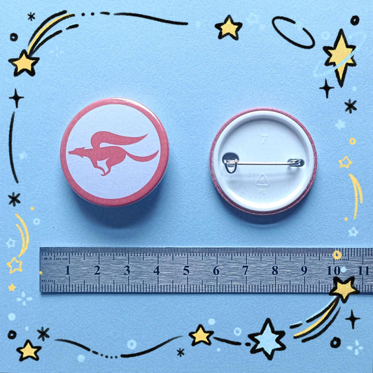 Photo of 2 of the StarFox team logo badges, one that shows the back of the badge, and a ruler to show their approximate size.