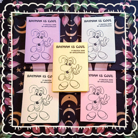 Photo of my Rayman mini 8-page zine in different pastel colours: purple, blue, yellow, green and pink.